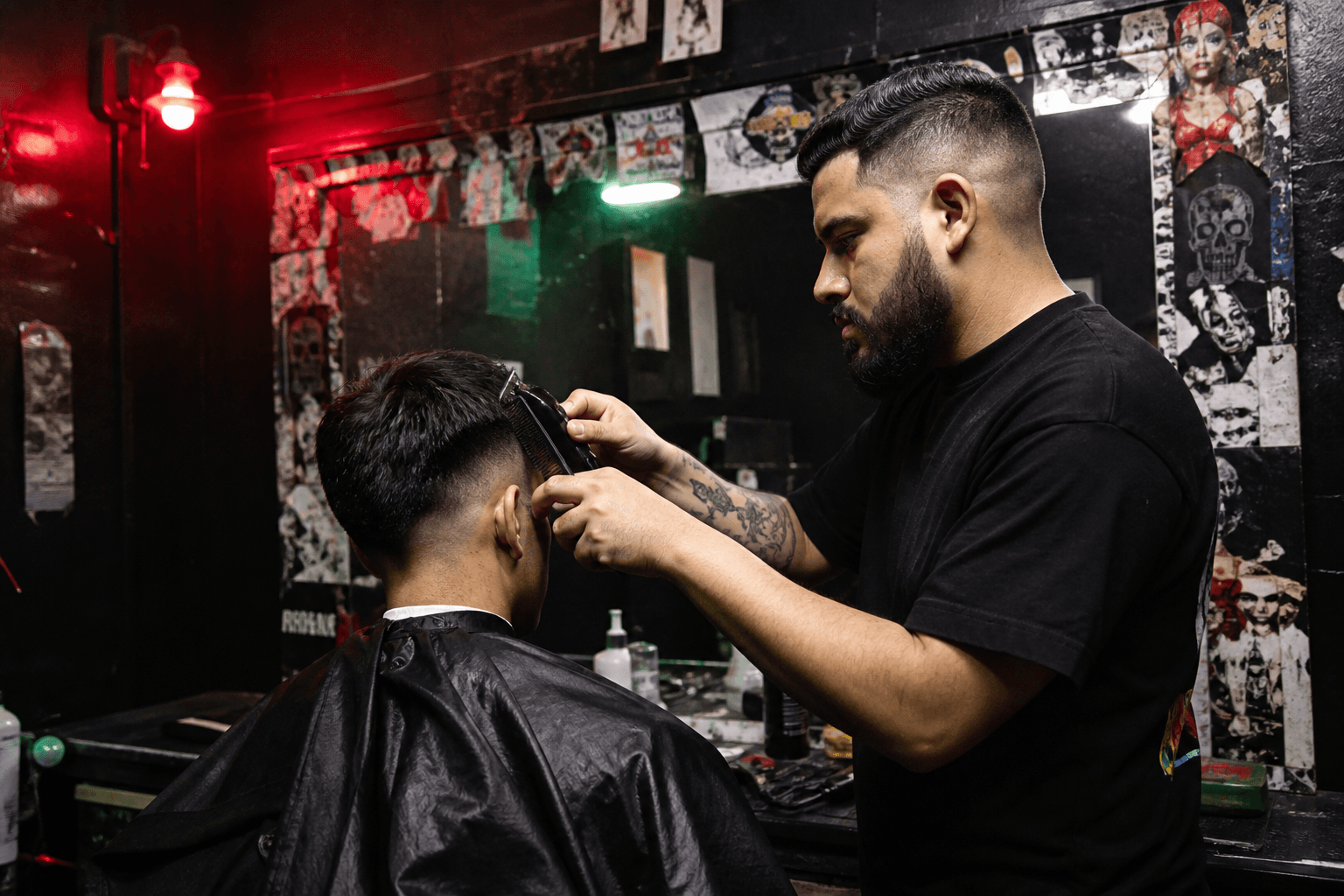 Barber giving a skin fade under red shop light